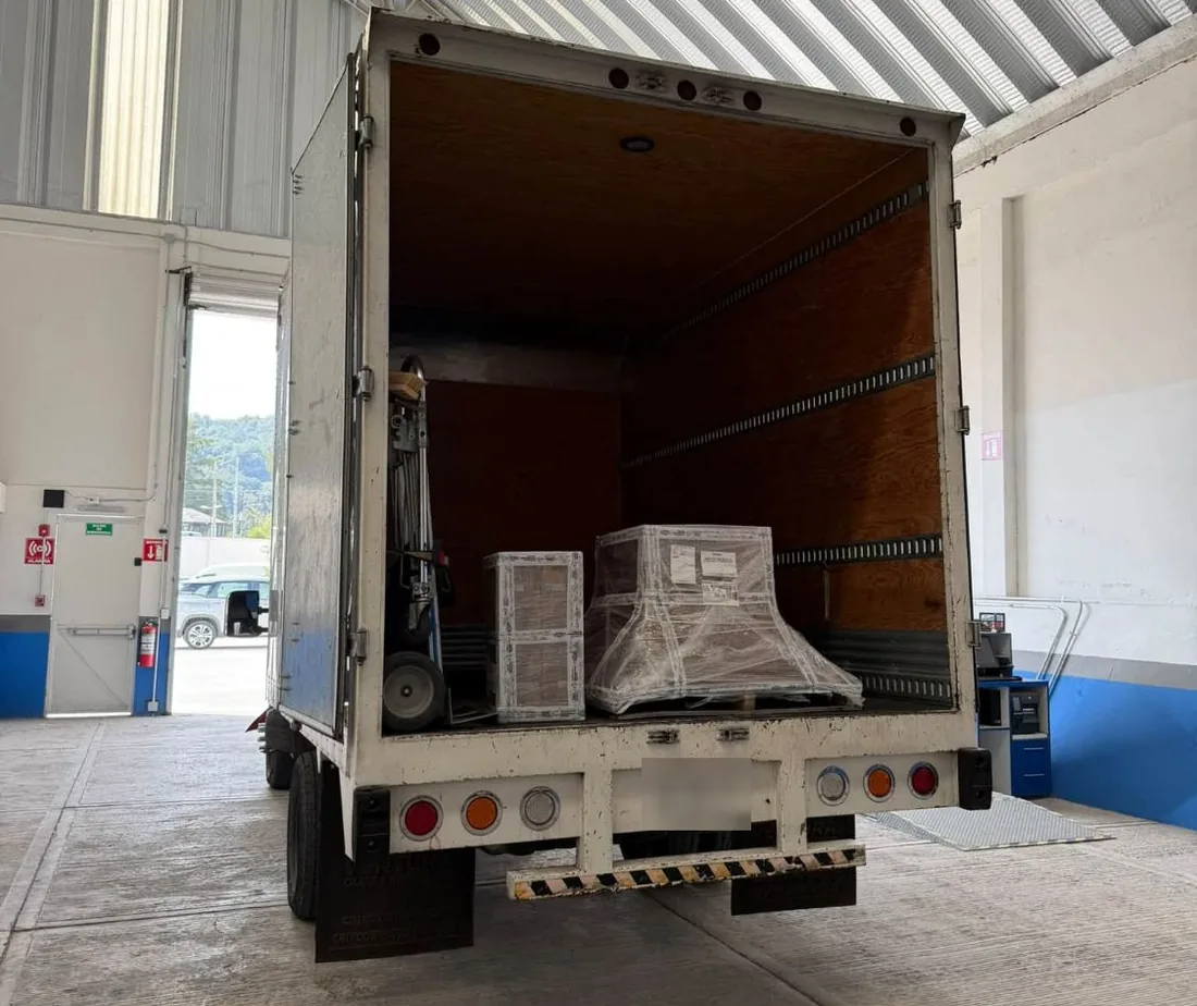Interior de la caja seca con carga comercial estibada y asegurada sobre tarima