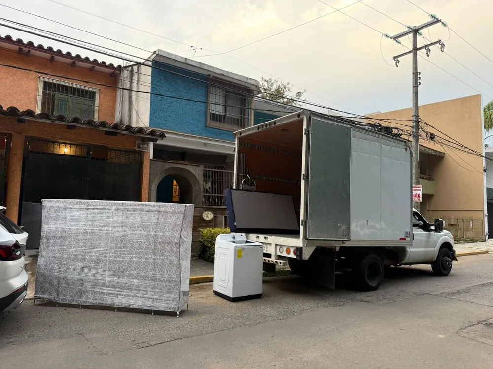 Muebles y electrodomésticos siendo cargados en la caja seca durante una mudanza